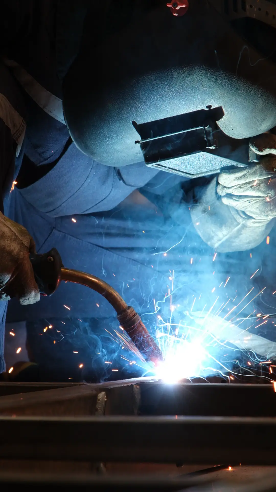 Intense welding process with sparks in an Istanbul industrial workshop, showcasing craftsmanship and safety.